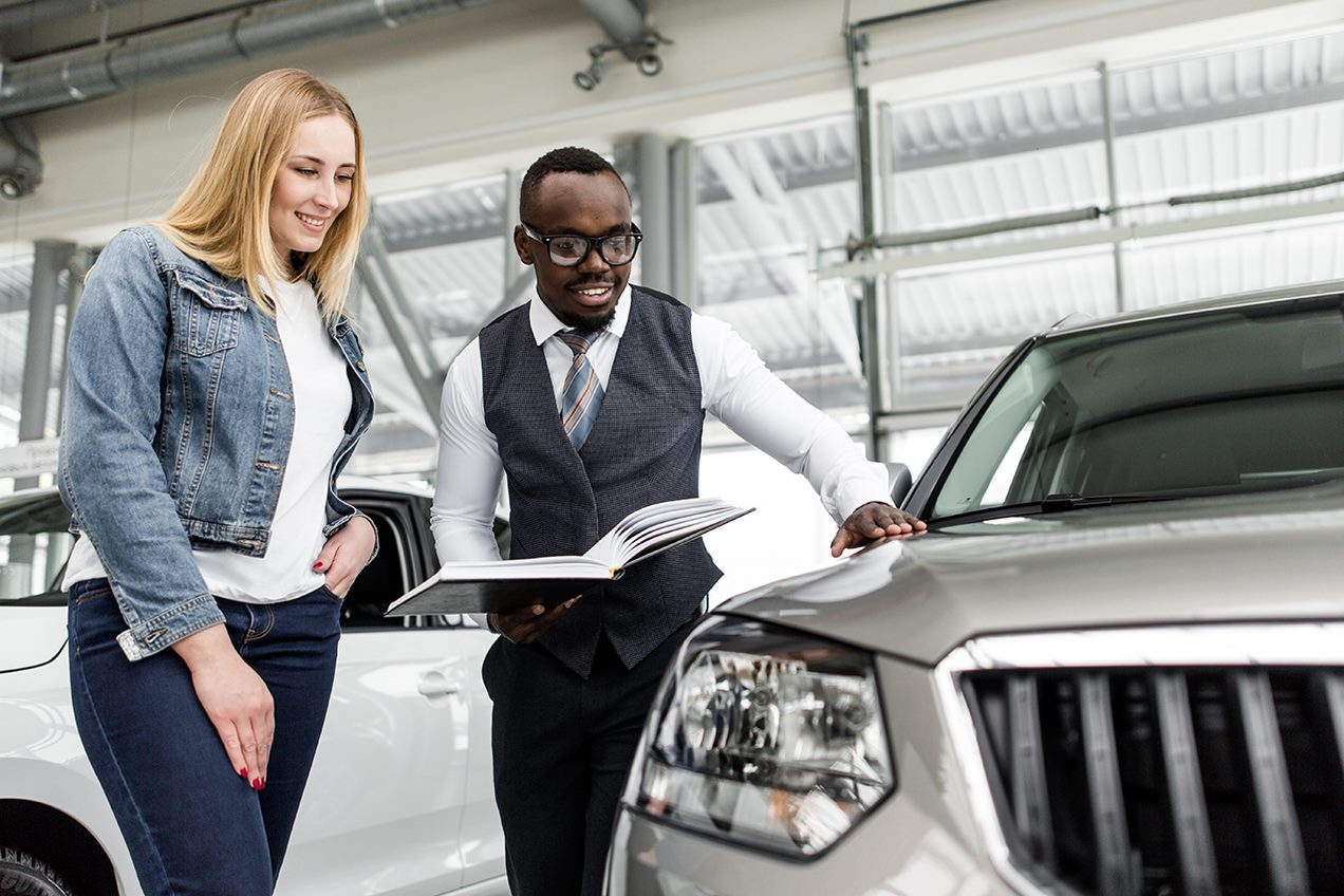 Salesman shows a woman a car